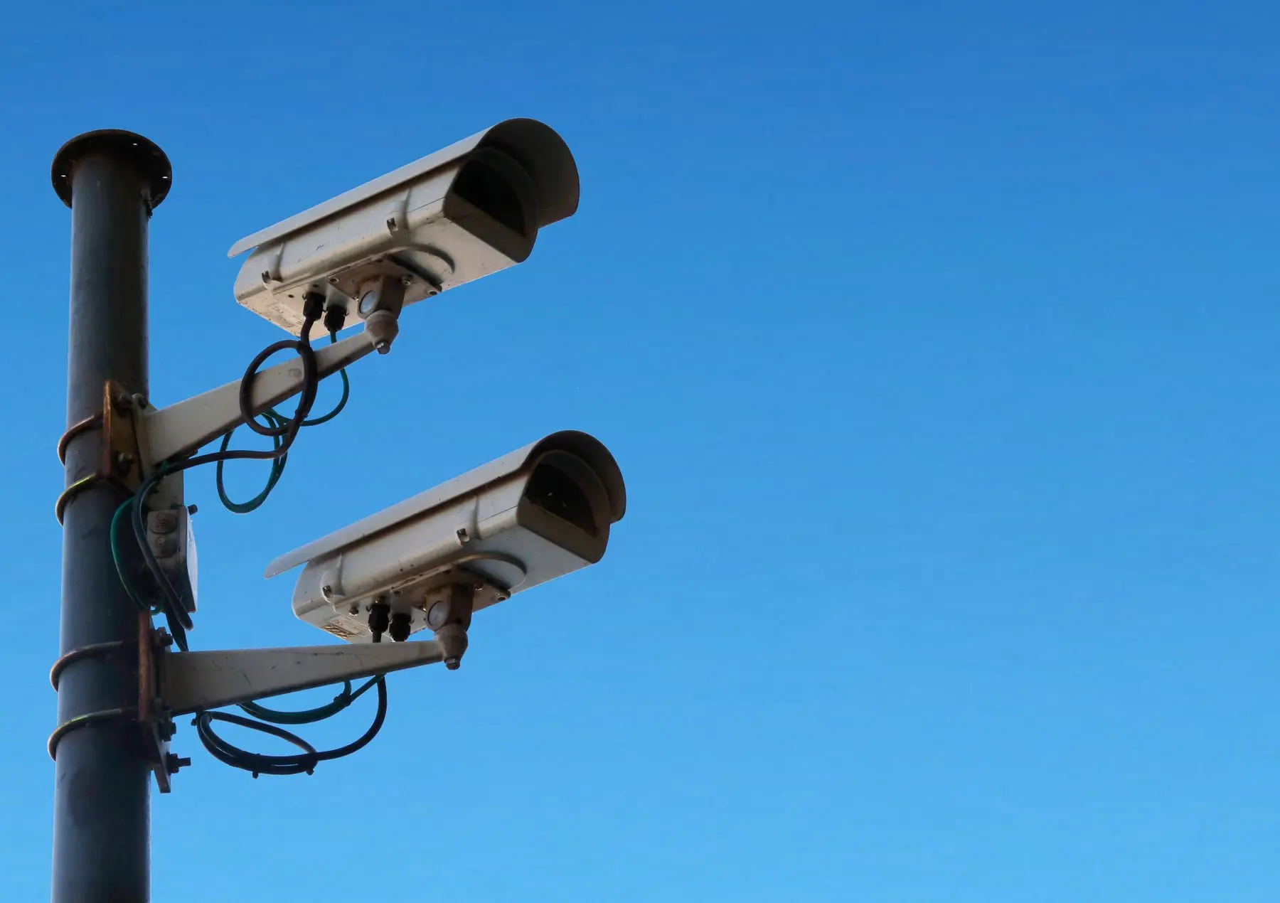 Two security cameras mounted on a pole